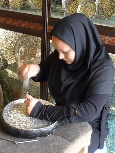 Kuenstlerin beim Silberteller schmuecken